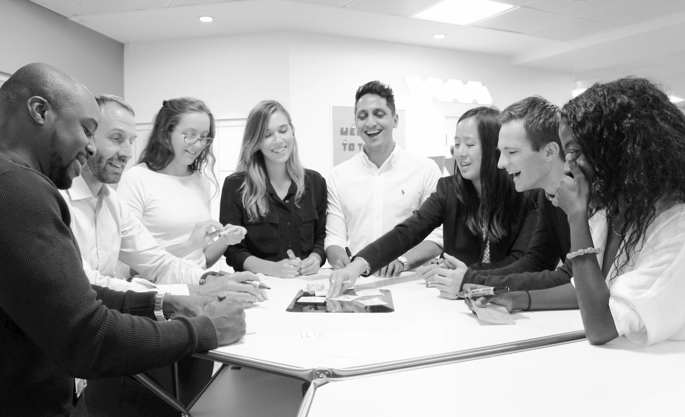 The AIE team gathered around in the office ideating.